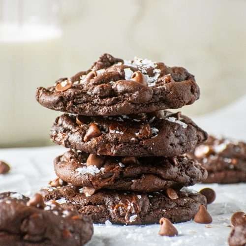 Close-up of freshly baked chewy double chocolate cookies stacked on a cooling rack
