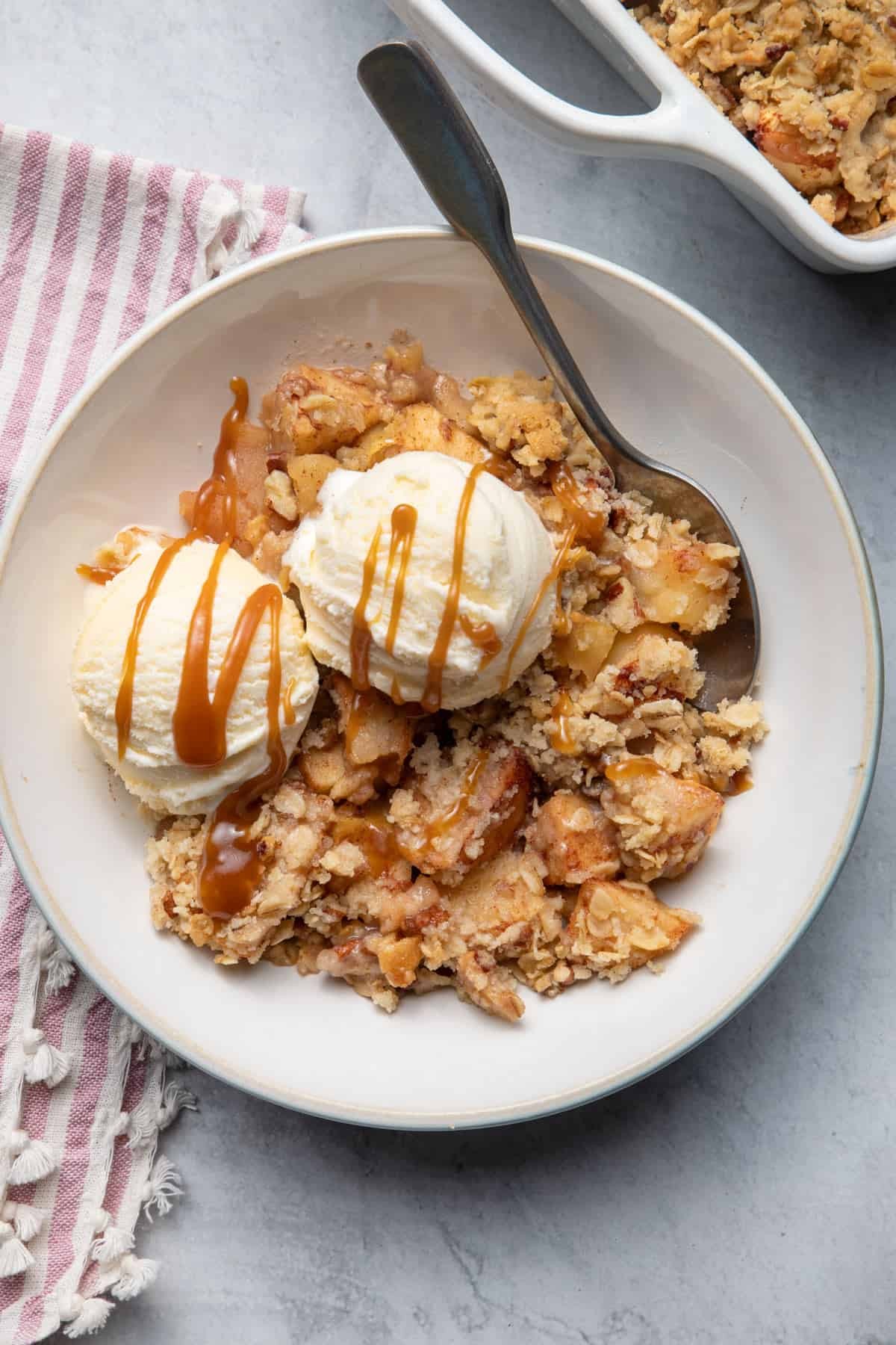 golden apple crisp with a scoop of vanilla ice cream