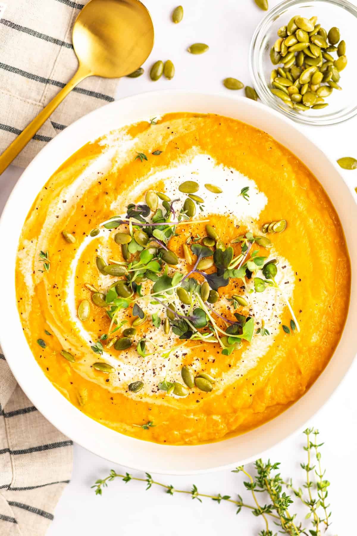 bowl of creamy pumpkin soup garnished with pepitas