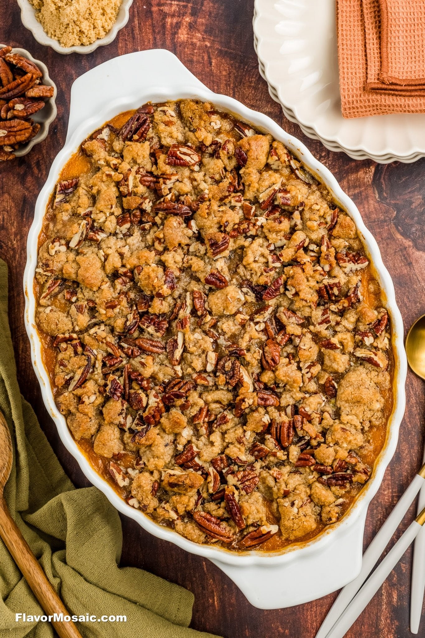 Sweet potato casserole with golden pecan topping on a rustic wooden table, cozy setting