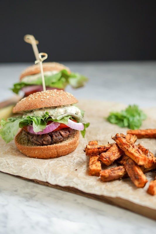 black bean burger with sweet potato fries on a wooden board