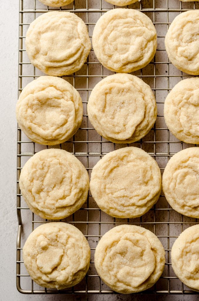 overhead shot of baked vanilla bean sugar cookies on a cooling rack, with visible vanilla specks