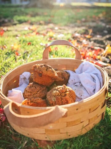 pumpkin cinnamon muffins on a wooden table, autumn leaves