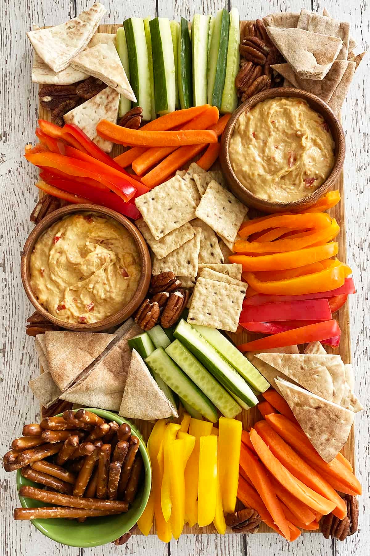 vibrant carrot and ginger hummus board with various dippers
