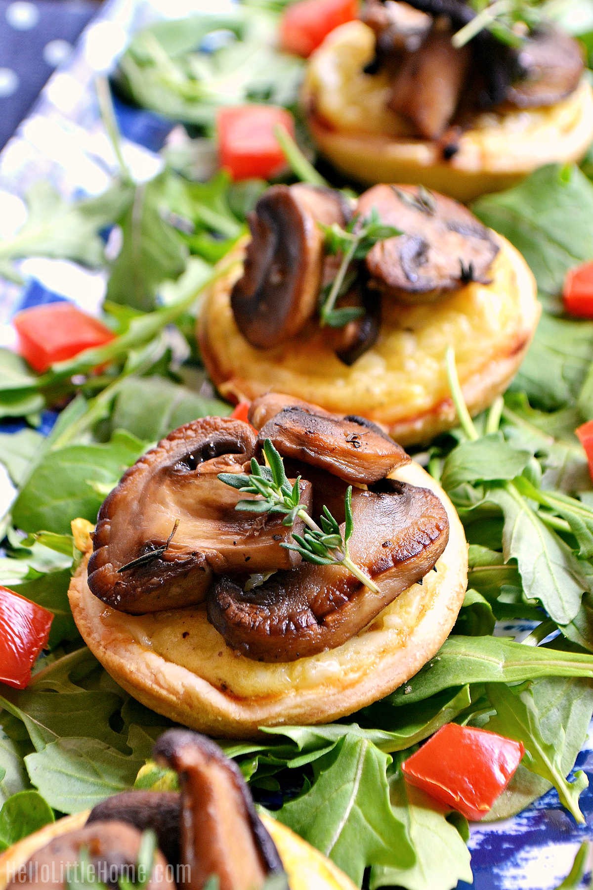 close-up of golden brown mini cheese tarts with fresh herbs, savory crust