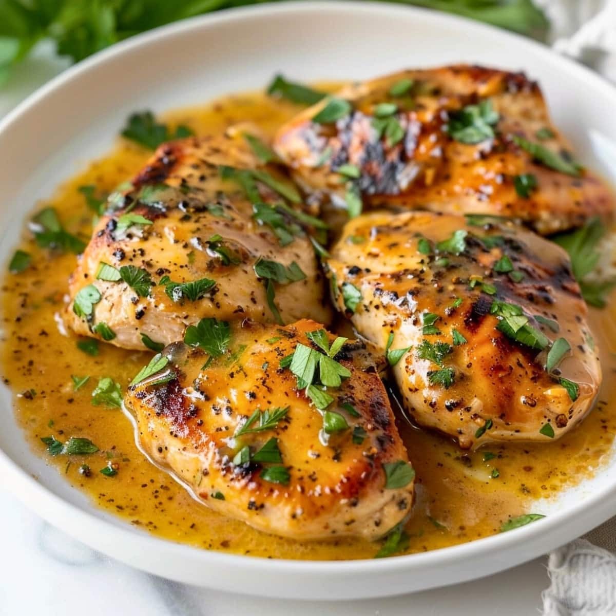 Golden brown honey mustard chicken breast on a plate with fresh parsley, close-up, warm lighting