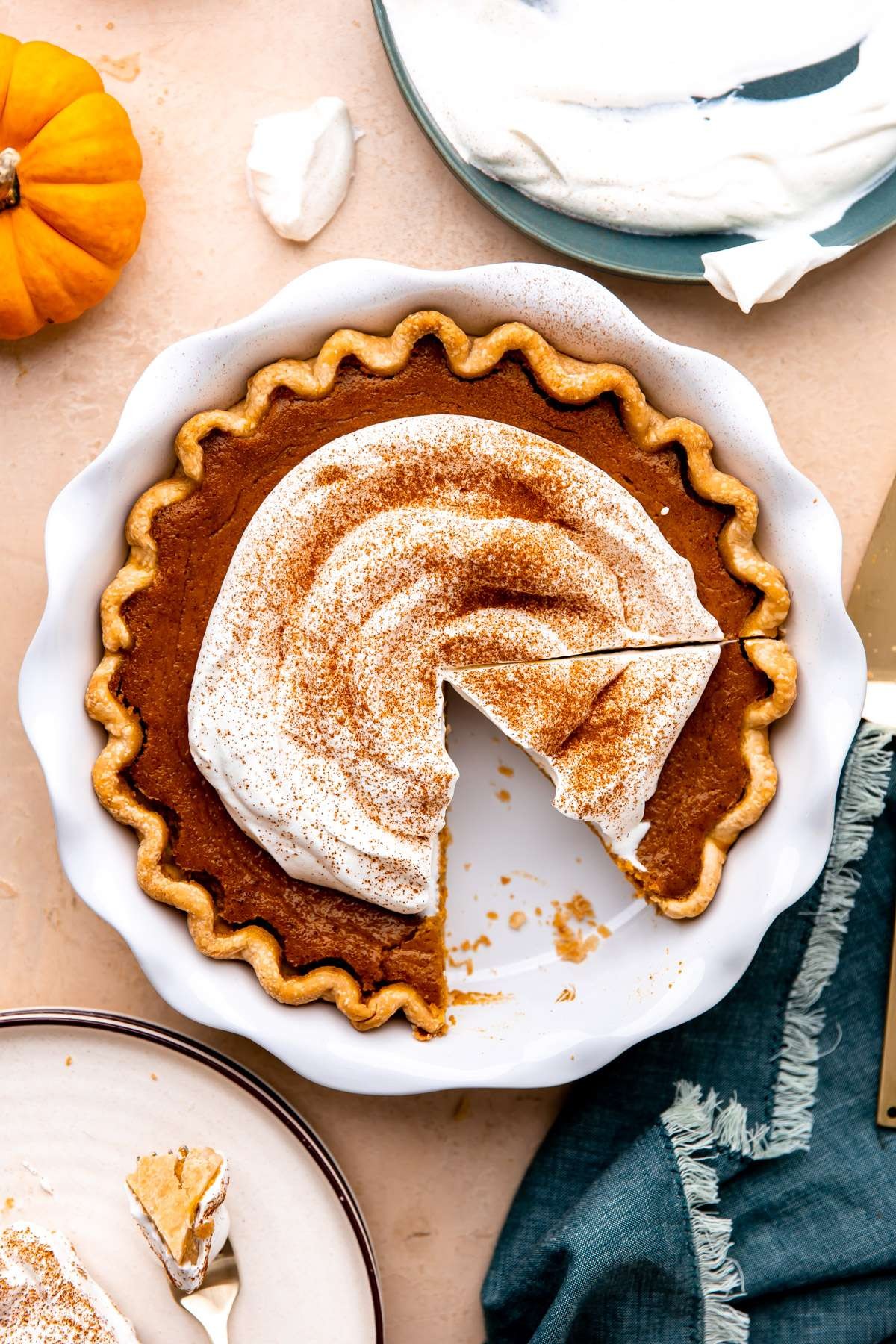 perfect slice of classic pumpkin pie with fresh whipped cream, festive background