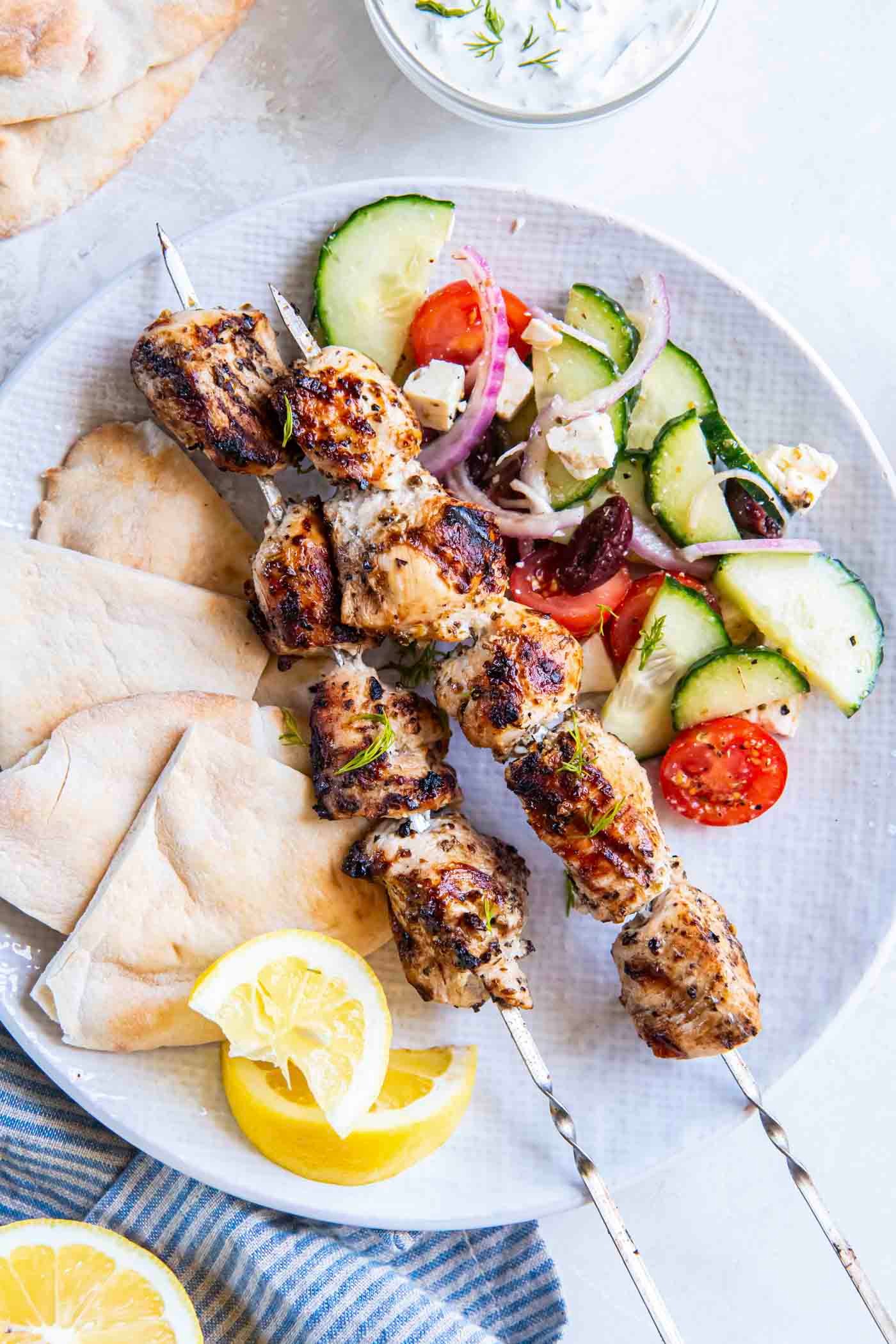 Lemony Chicken Souvlaki skewers served on warm pita bread with a side of tzatziki sauce