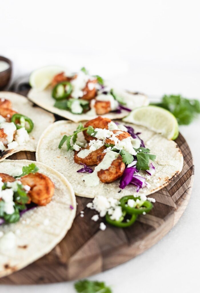 Chipotle shrimp tacos with cabbage slaw on a wooden table
