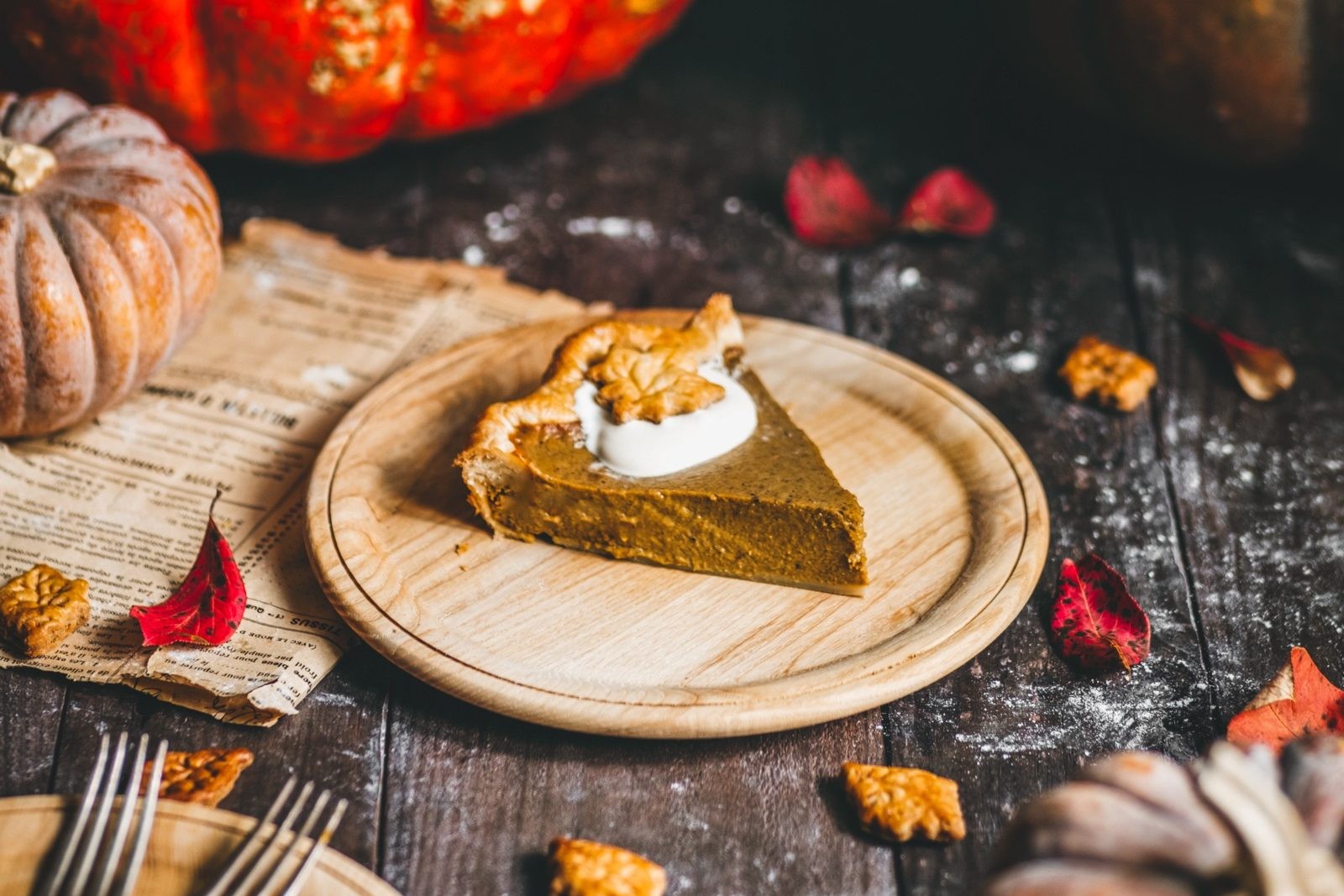 Rustic maple pumpkin pie with flaky crust and a hint of steam, surrounded by autumn leaves and spices
