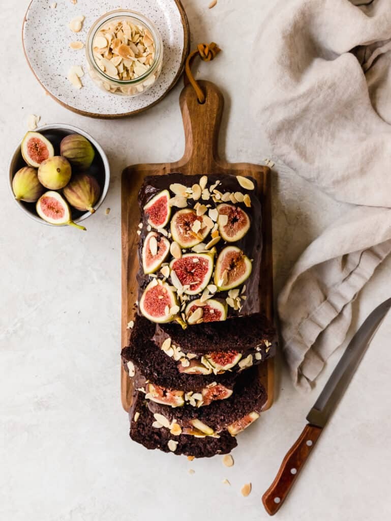Fig balsamic chocolate cake on a rustic wooden table with figs and balsamic glaze