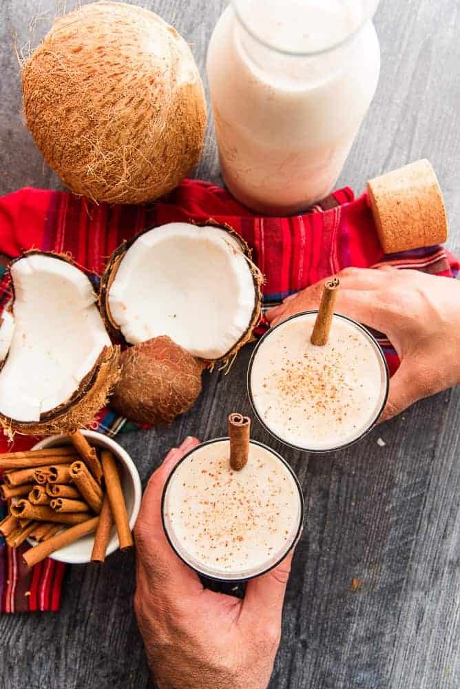 festive Coquito drink with toasted coconut flakes and cinnamon stick, holiday setting