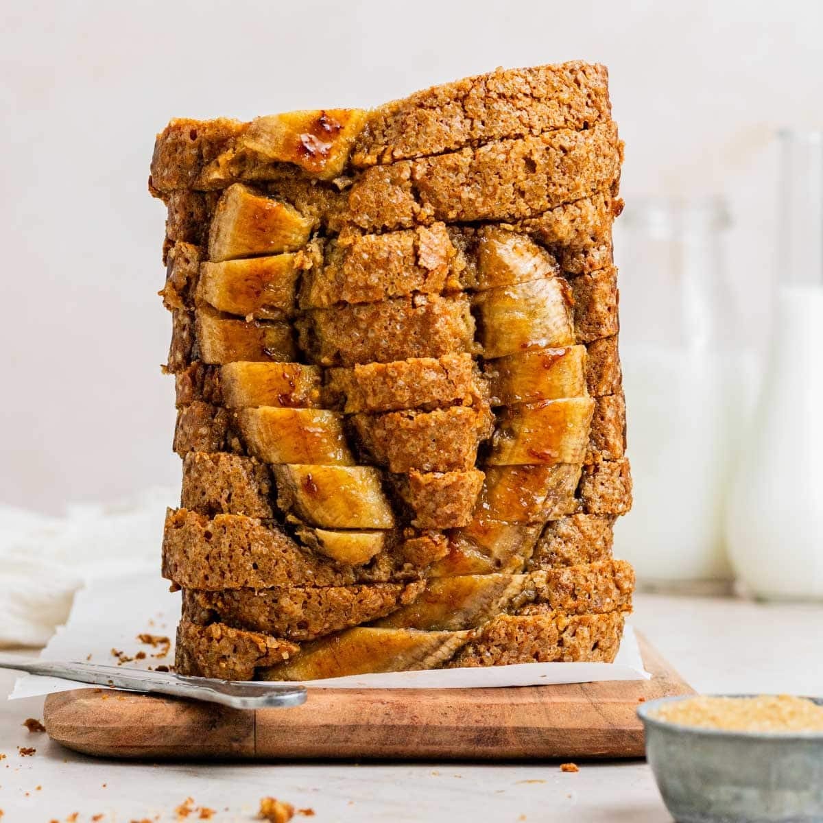 Deliciously moist banana toffee bread loaf on a wooden cutting board, drizzled with caramel sauce, warm and inviting