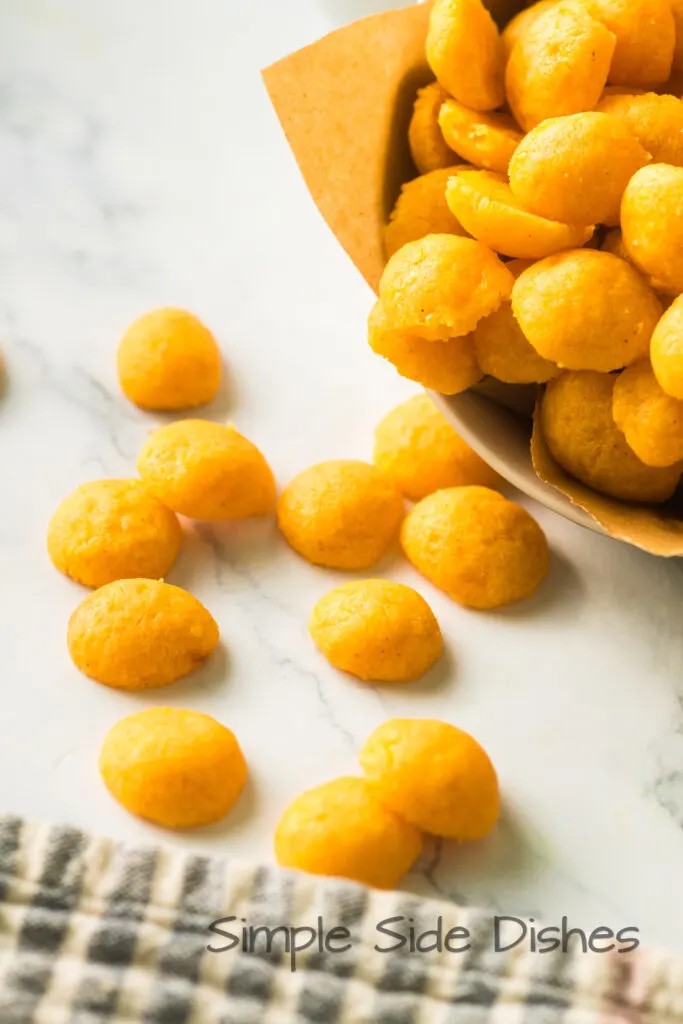 golden brown savory cheese puffs on a baking sheet, close up, warm lighting