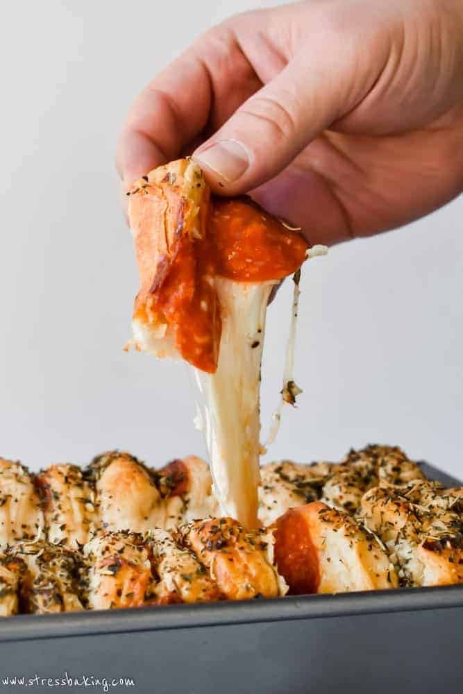 close up of pizza mac and cheese being pulled apart with visible cheese stretching
