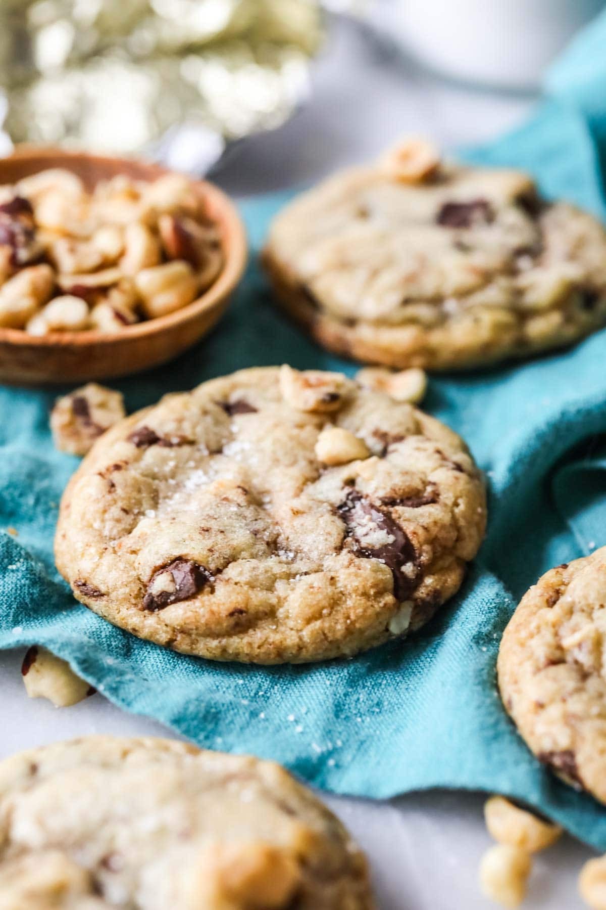 close-up shot of golden-brown hazelnut cookies with chopped hazelnuts on a rustic wooden table