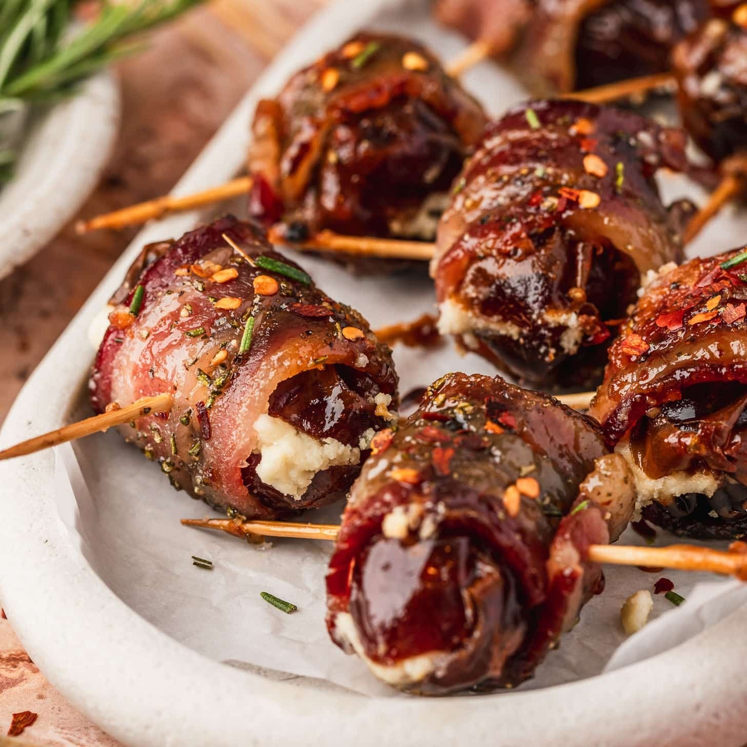 bacon wrapped dates on a platter with glaze, close-up, appetizer style