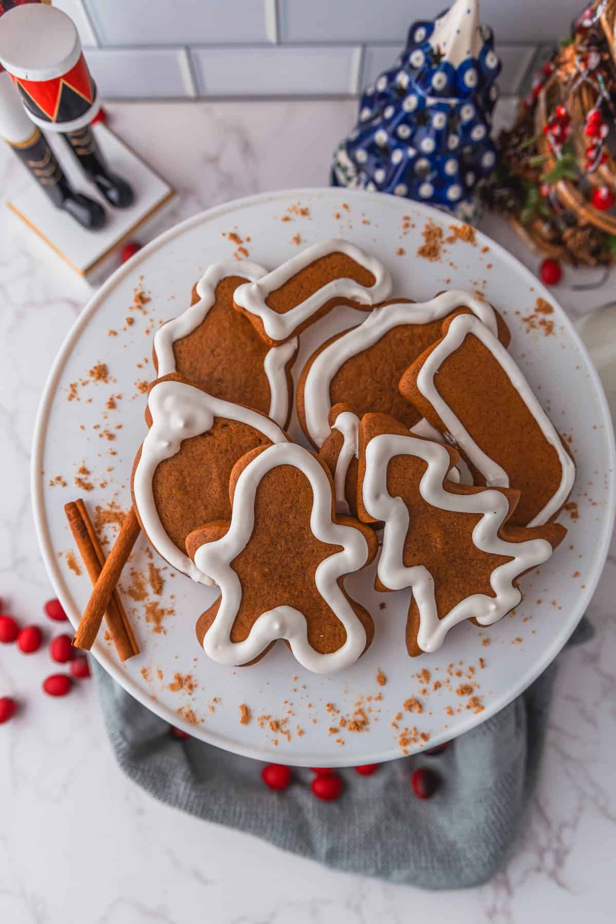 Warm, perfectly baked gingerbread cookies on a festive platter with a dusting of powdered sugar and cozy spices around