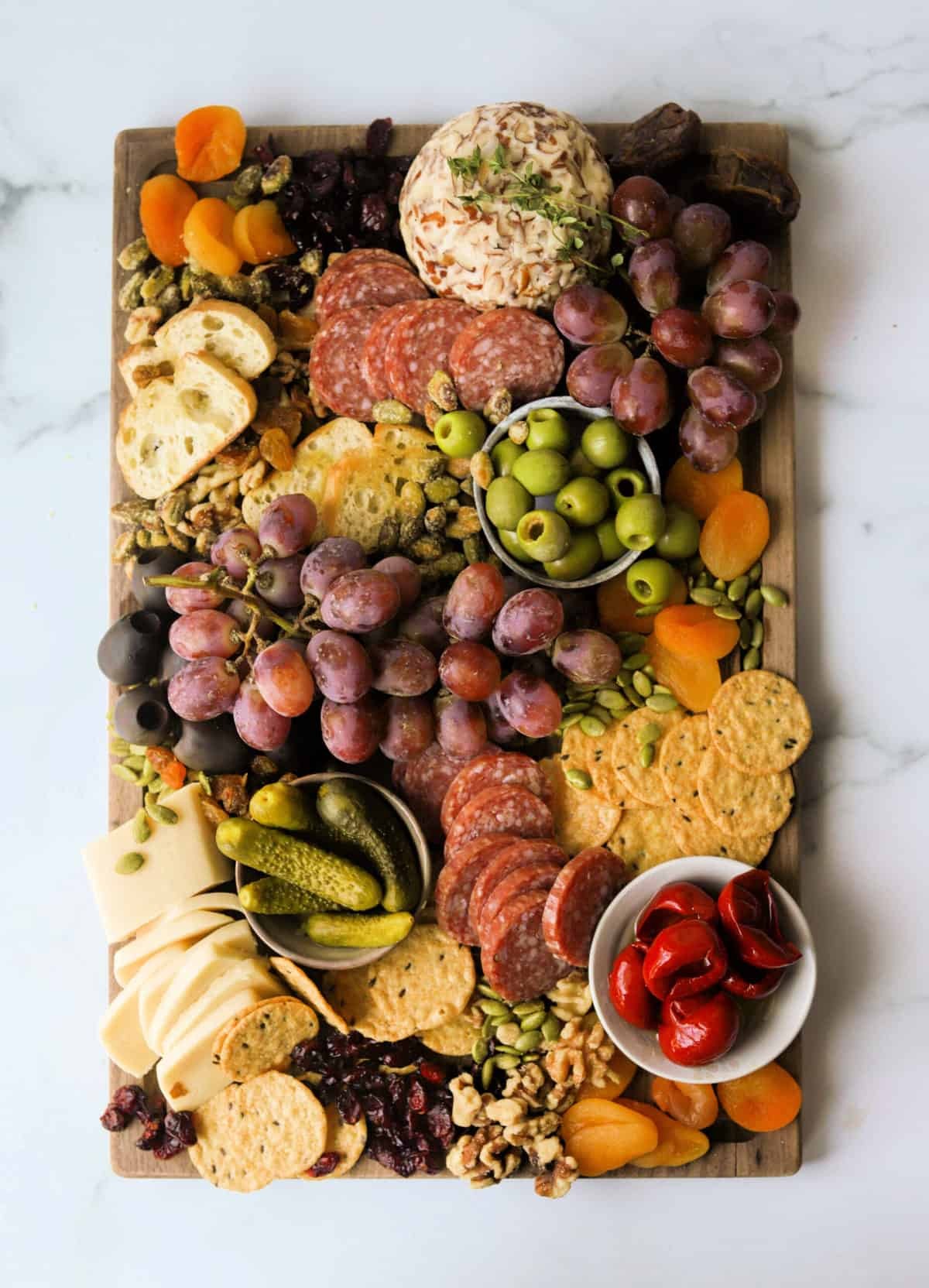 overhead shot of a beautifully arranged dried mango charcuterie board with various cheeses, nuts, fruits, and crackers