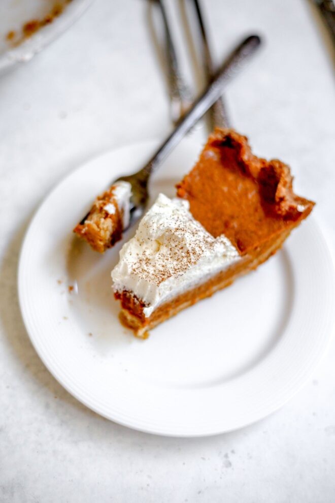 slice of silky pumpkin pie with toasted spice crust, autumn leaves, cozy setting