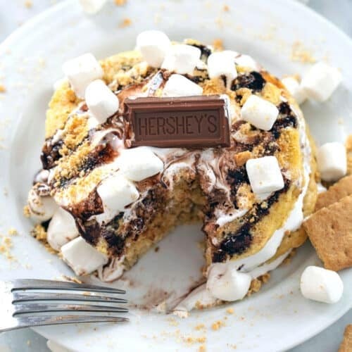 stack of s'mores gluten-free pancakes drizzled with chocolate sauce and marshmallow fluff