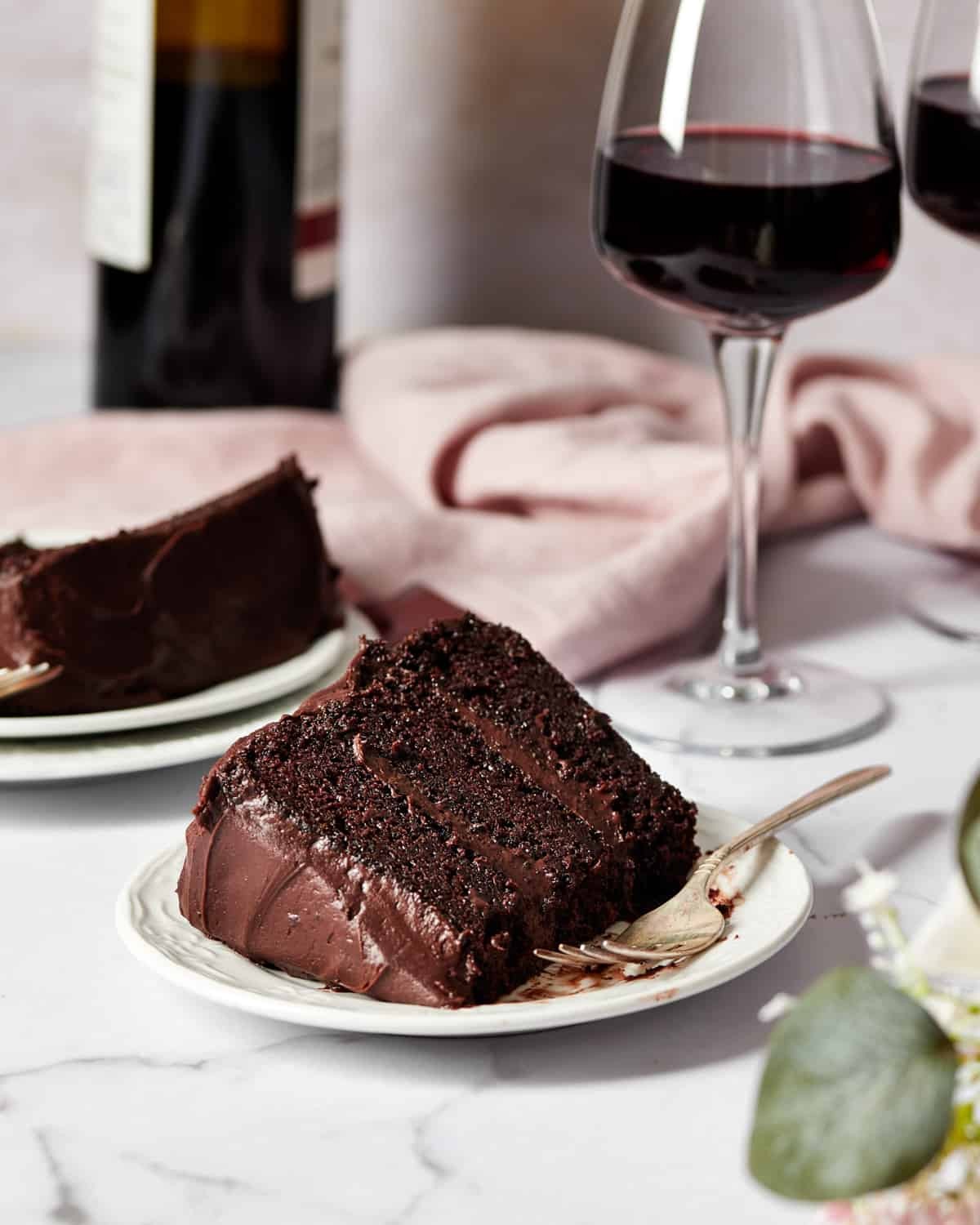 slice of red wine chocolate velvet cake with a glass of red wine