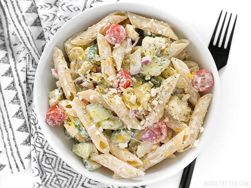 bowl of yogurt dill pasta salad with fresh dill and lemon slices