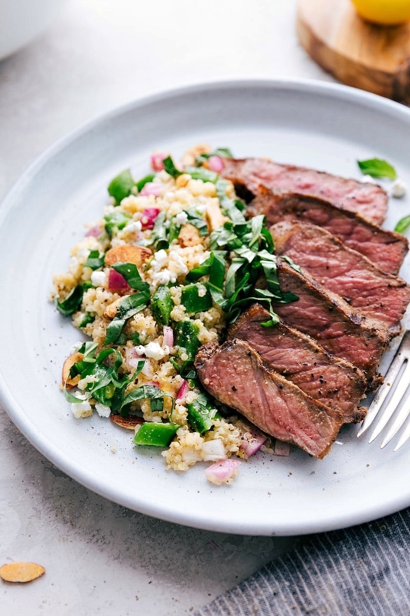 steak served over a bed of quinoa salad with lemon-herb dressing