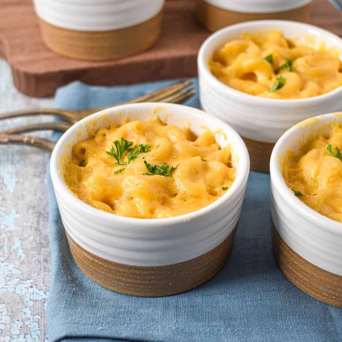 Golden brown cream-top mac and cheese in individual ramekins, steam rising