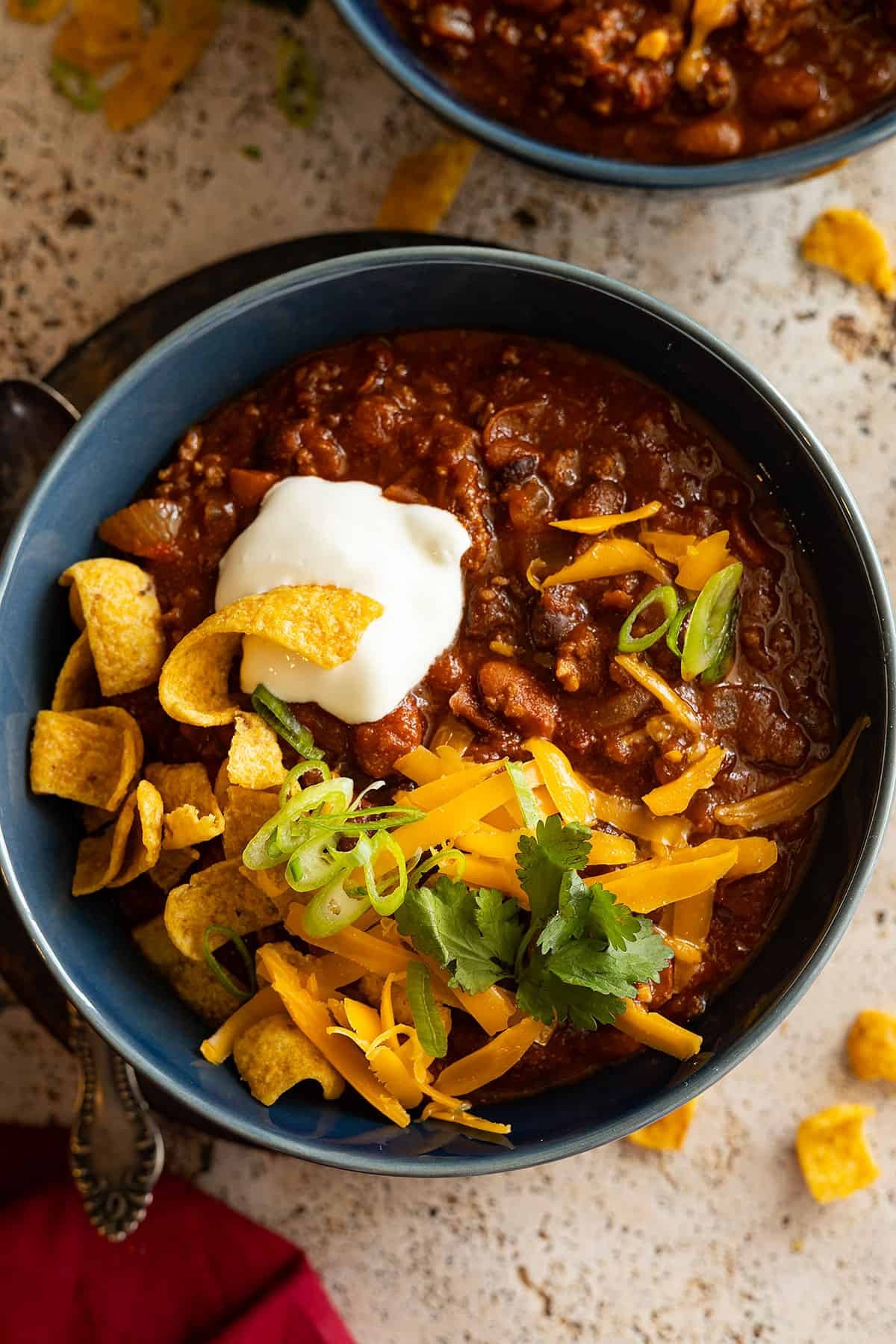 slow cooker chili in a bowl topped with cheese and sour cream