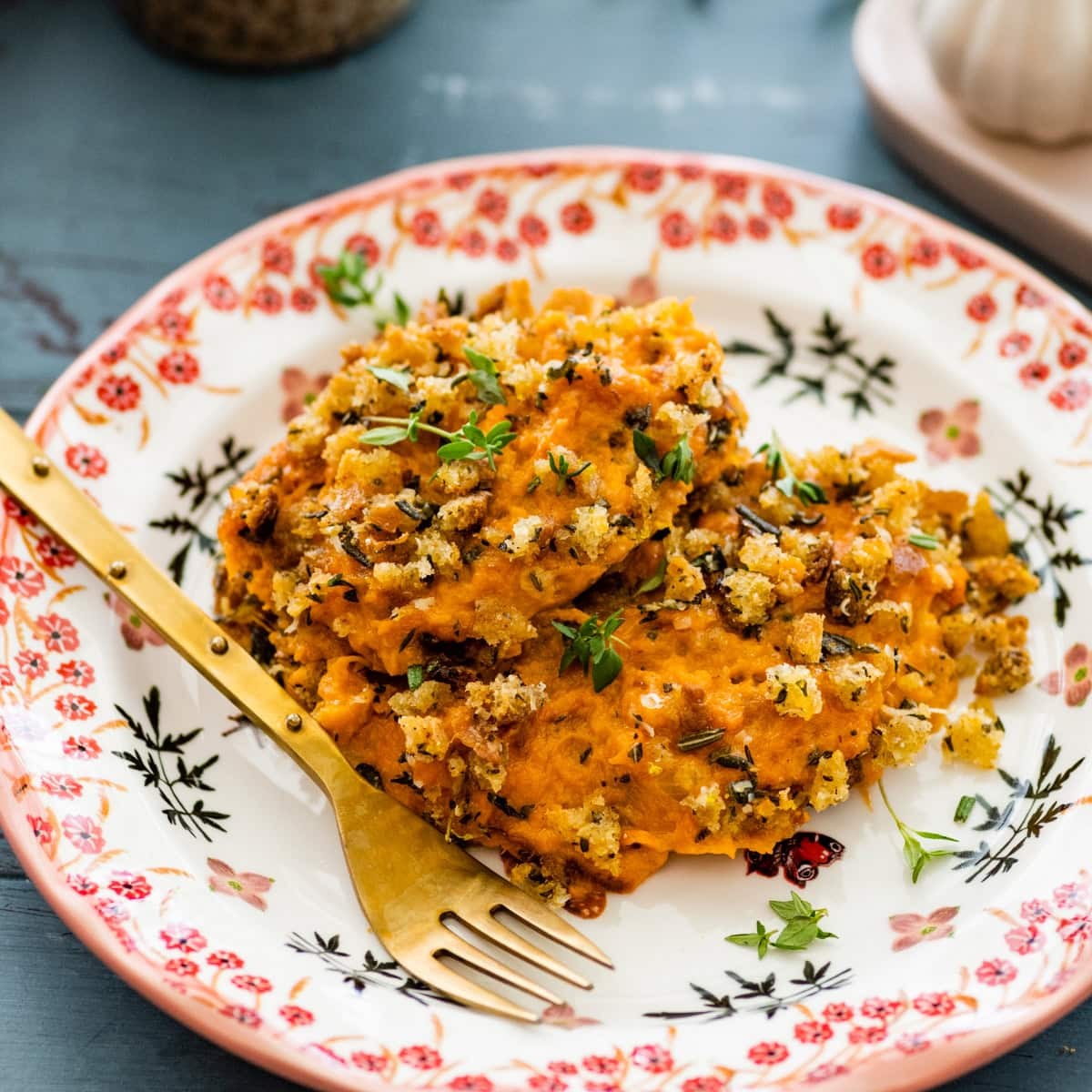 savory sweet potato casserole with fresh herbs on a festive table