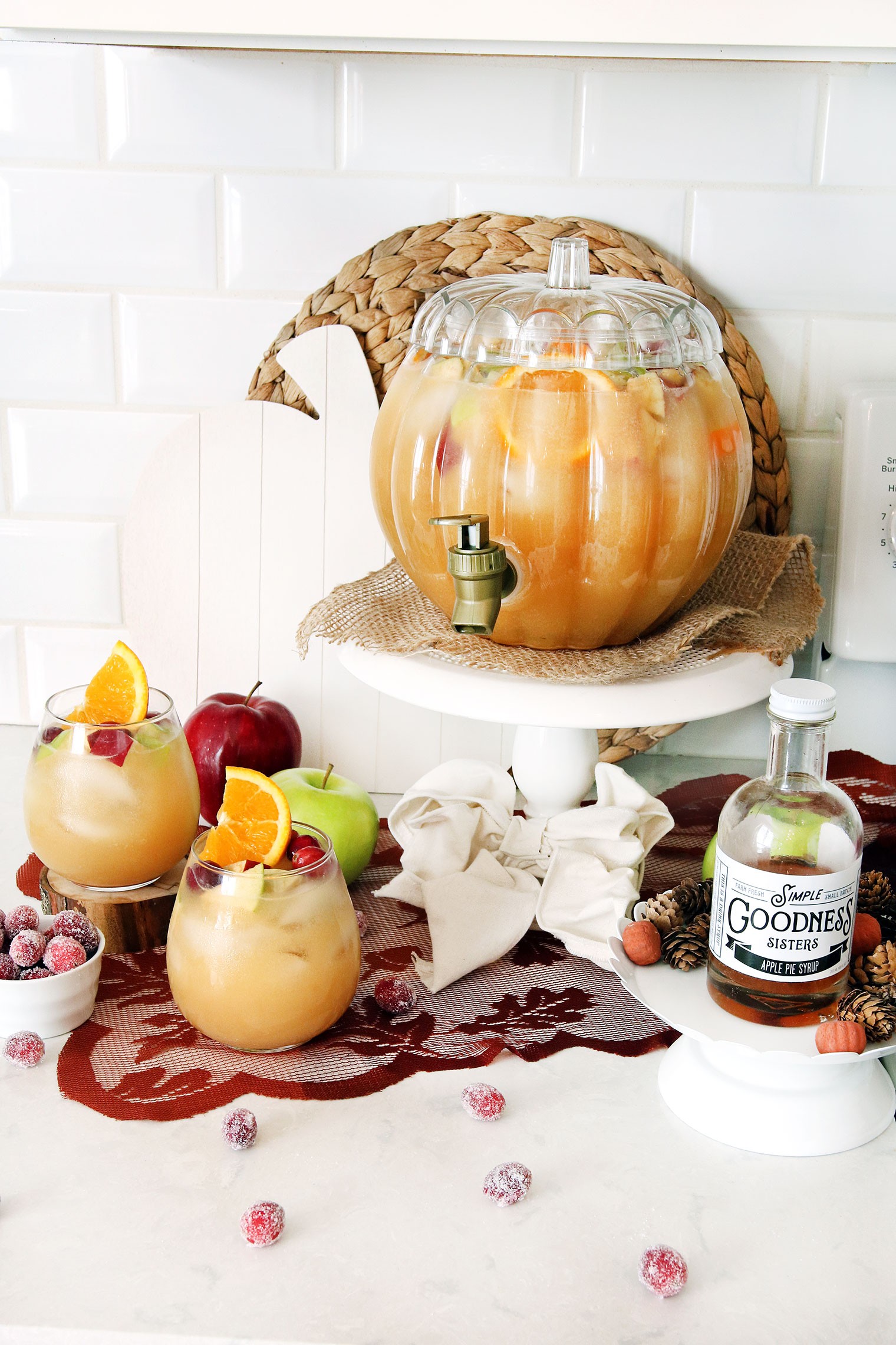 Delicious caramel apple punch in a large punch bowl with sliced apples and caramel drizzle, surrounded by fall decor, Friendsgiving party atmosphere
