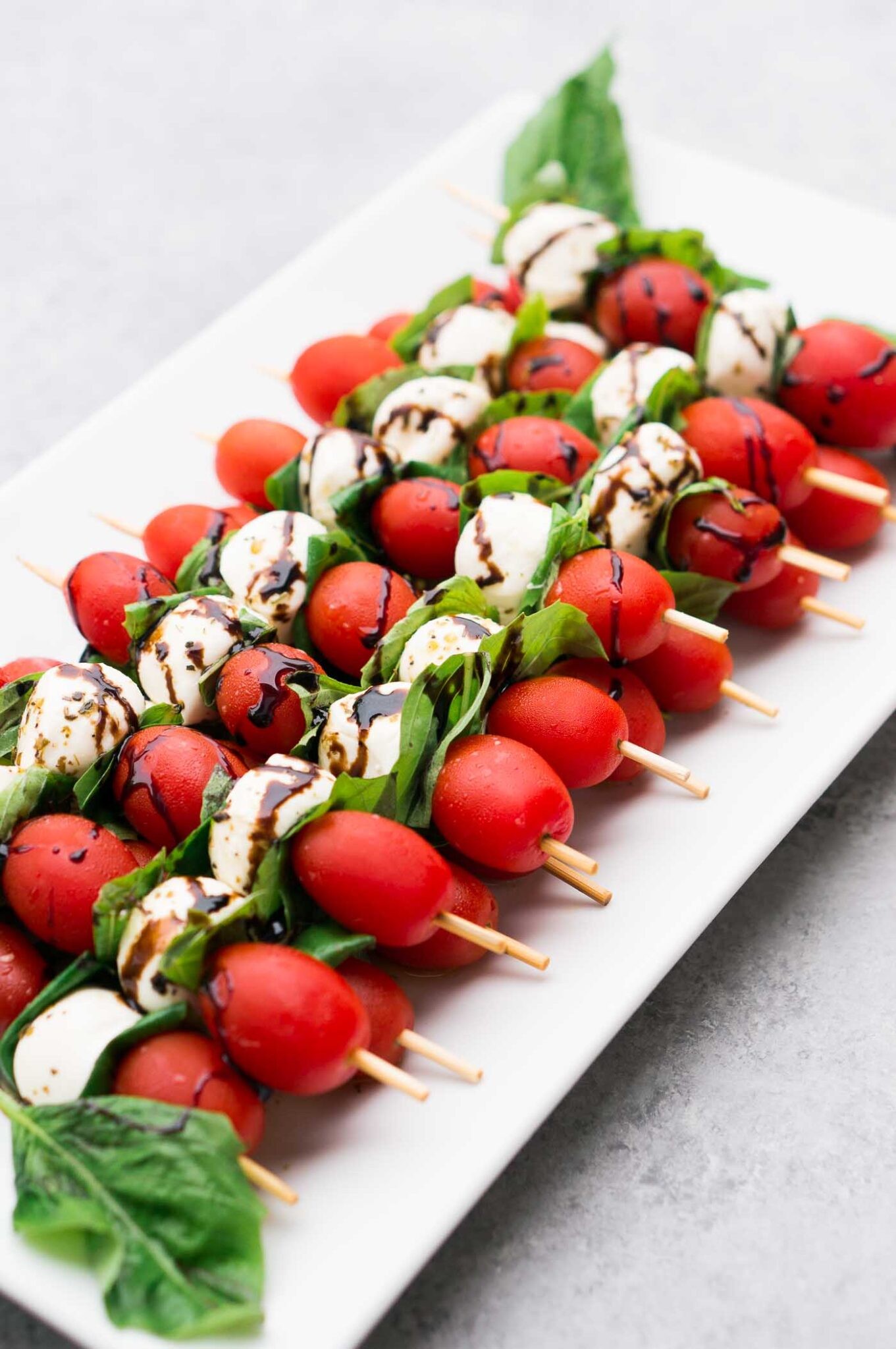 Caprese salad skewers drizzled with balsamic reduction
