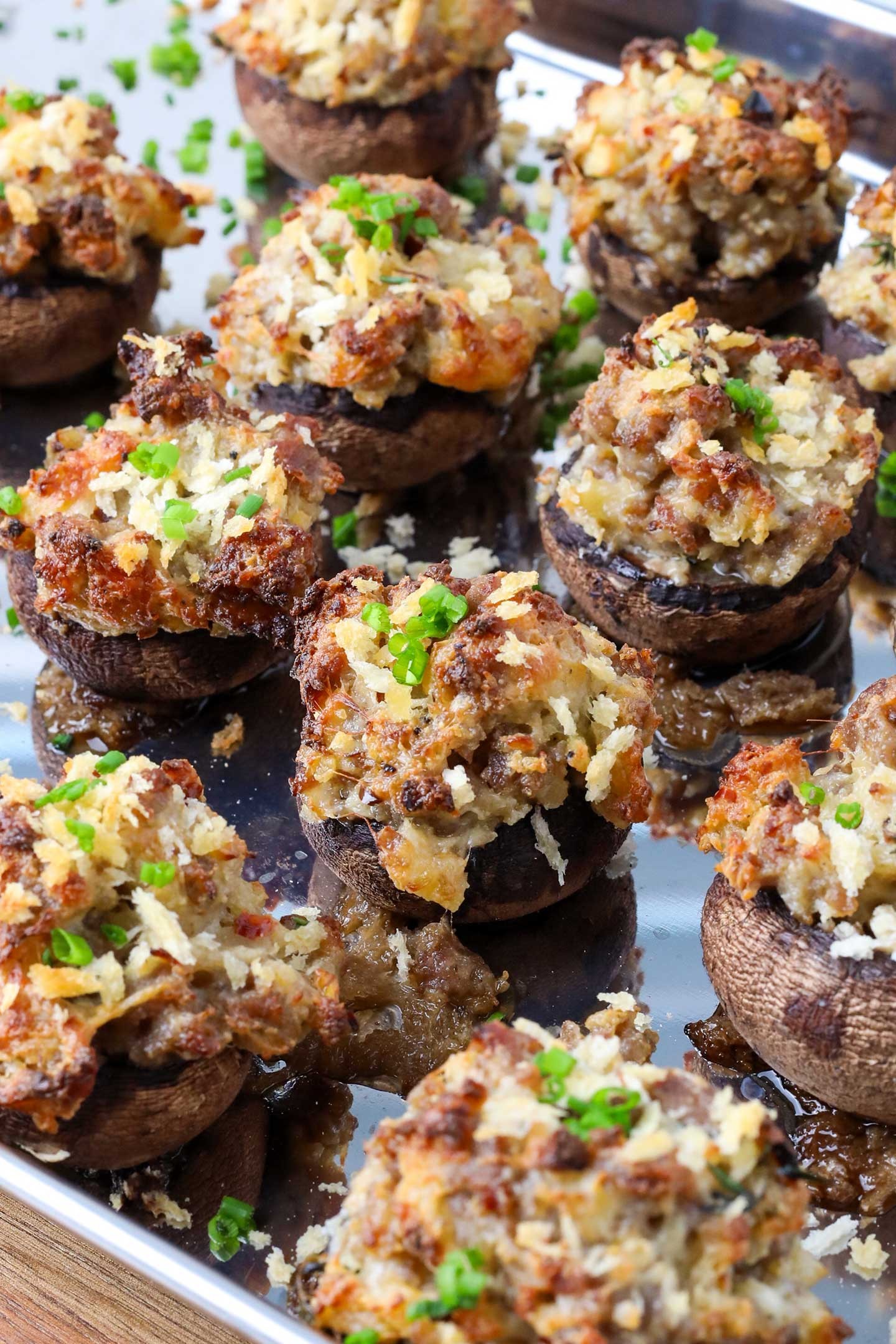 gourmet sausage stuffed mushrooms with crispy herb crust on a rustic platter, bokeh background