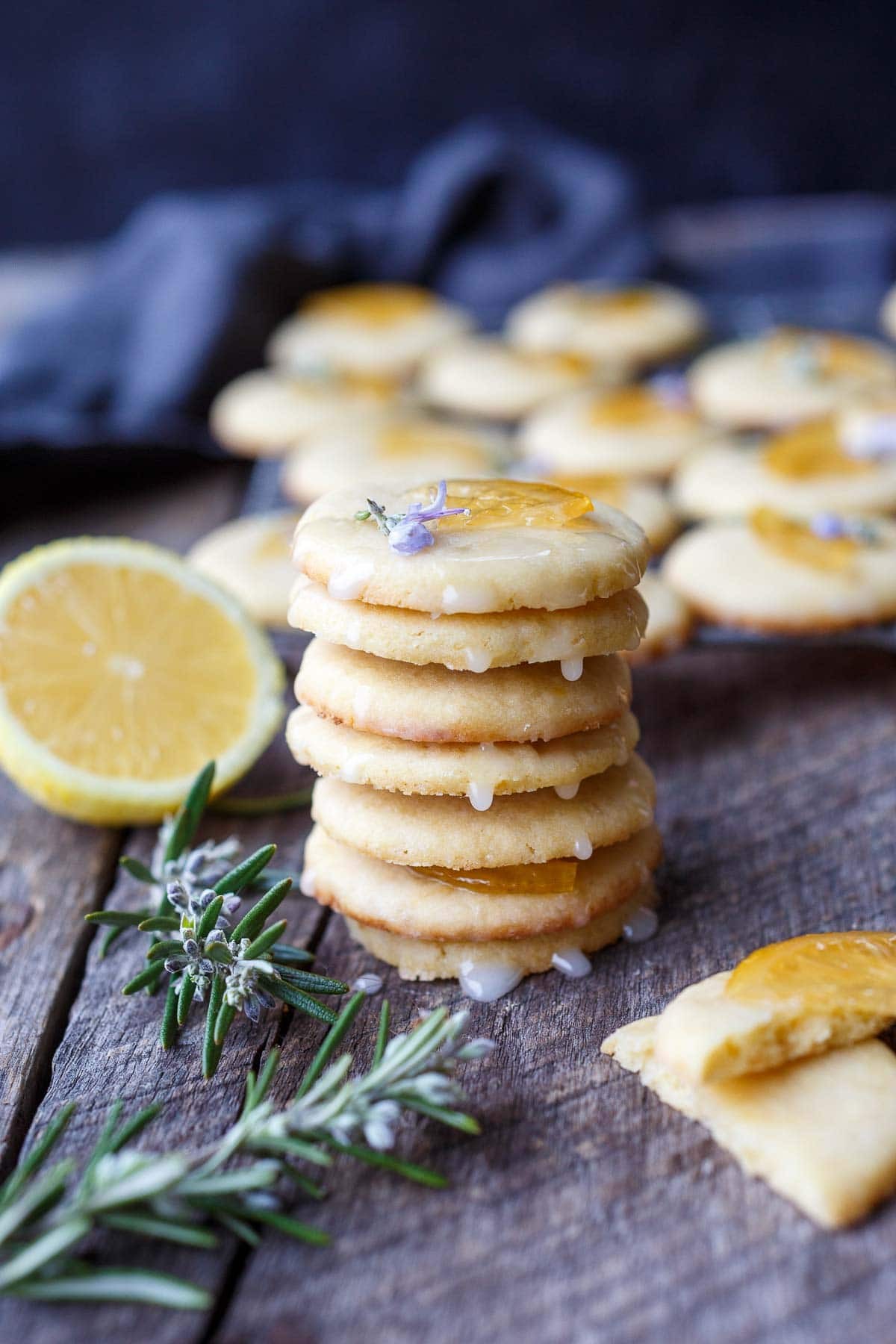 Vibrant lemon cookies with bright yellow glaze and fresh lemon zest on a rustic wooden table