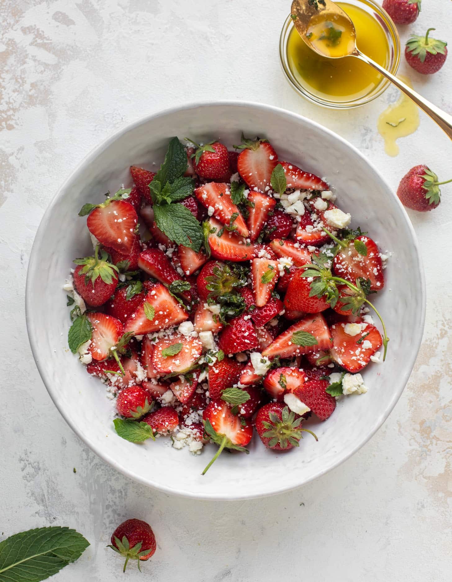 close-up of a vibrant strawberry feta salad with xylitol sprinkles, garnished with fresh mint