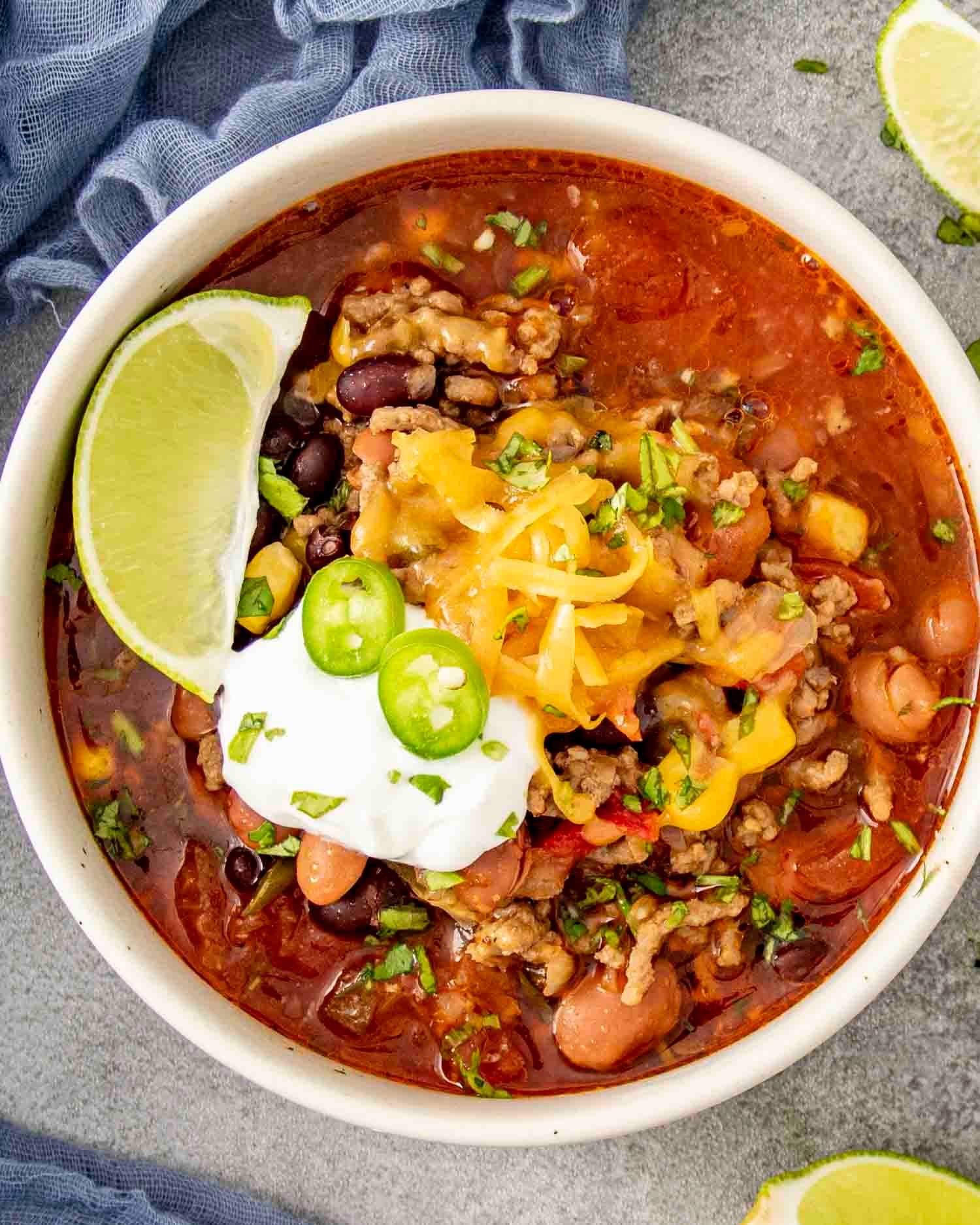 cozy bowl of creamy taco soup with a dollop of sour cream, fresh cilantro, and a lime wedge, in a warm, inviting setting