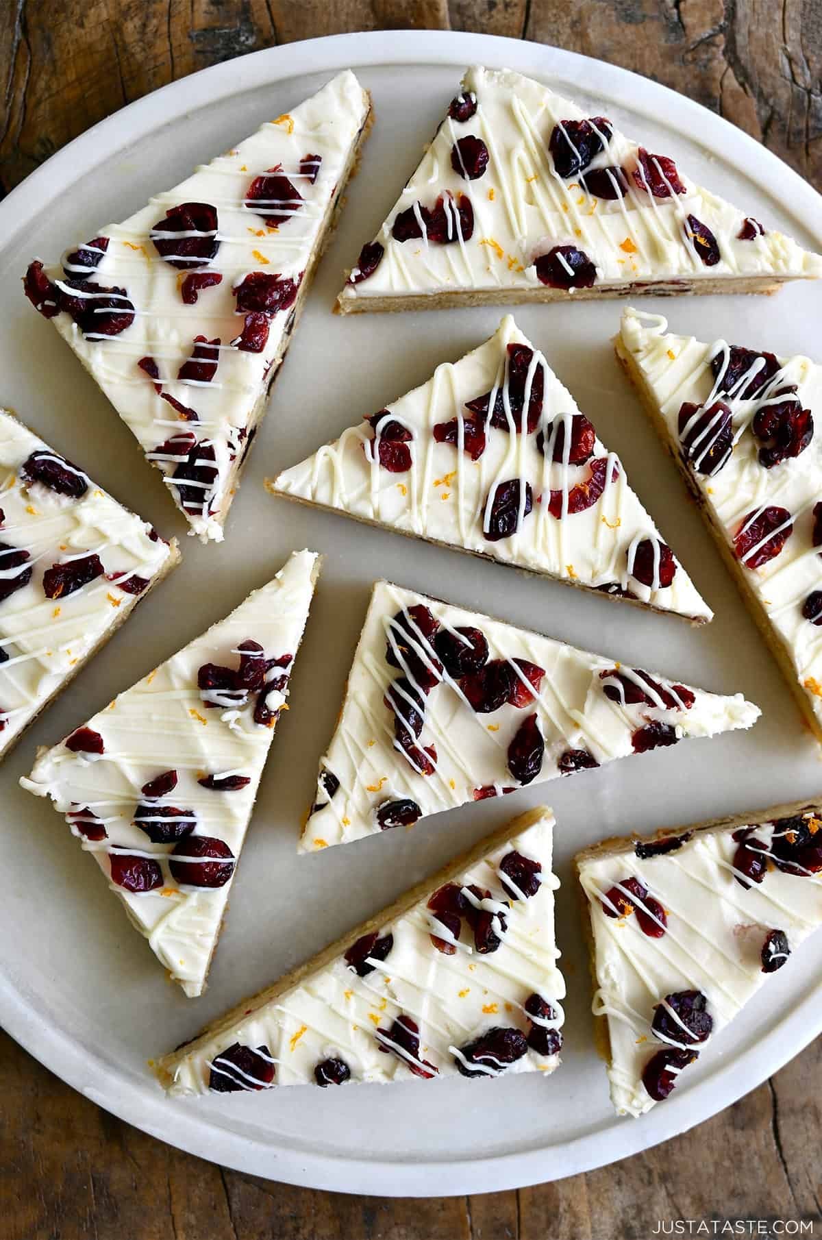 Platter of cranberry bliss bars with white chocolate drizzle and orange zest