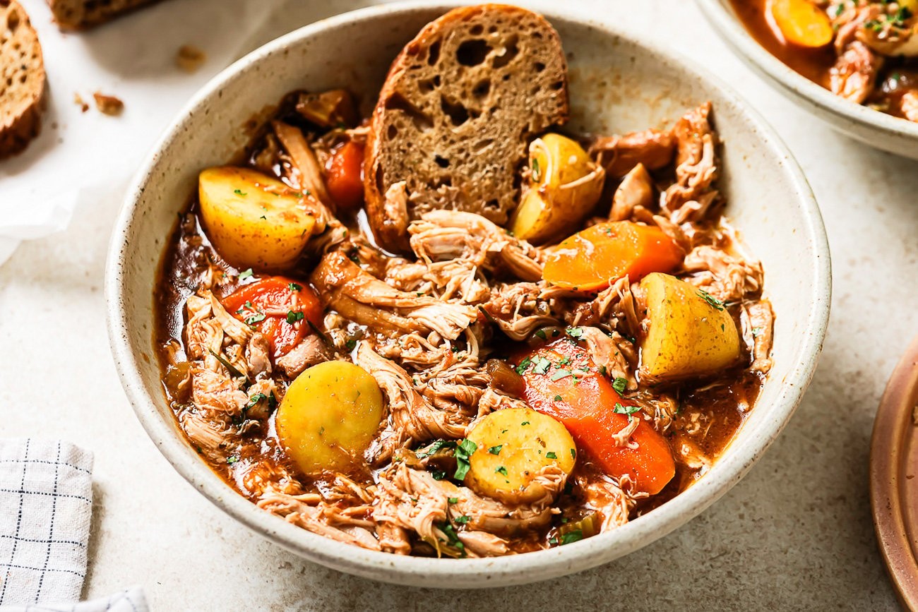rustic slow cooker chicken stew served in a bowl with crusty bread
