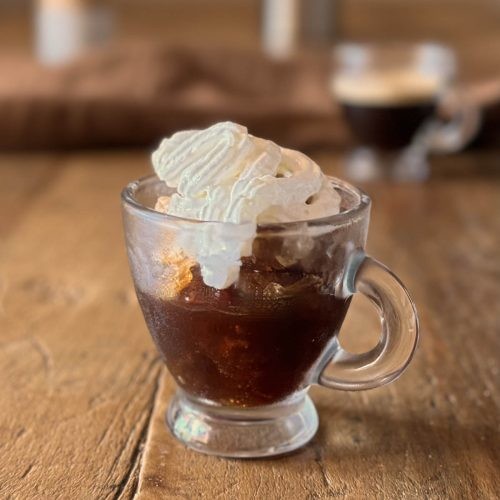 iced espresso con panna in a clear glass with whipped cream