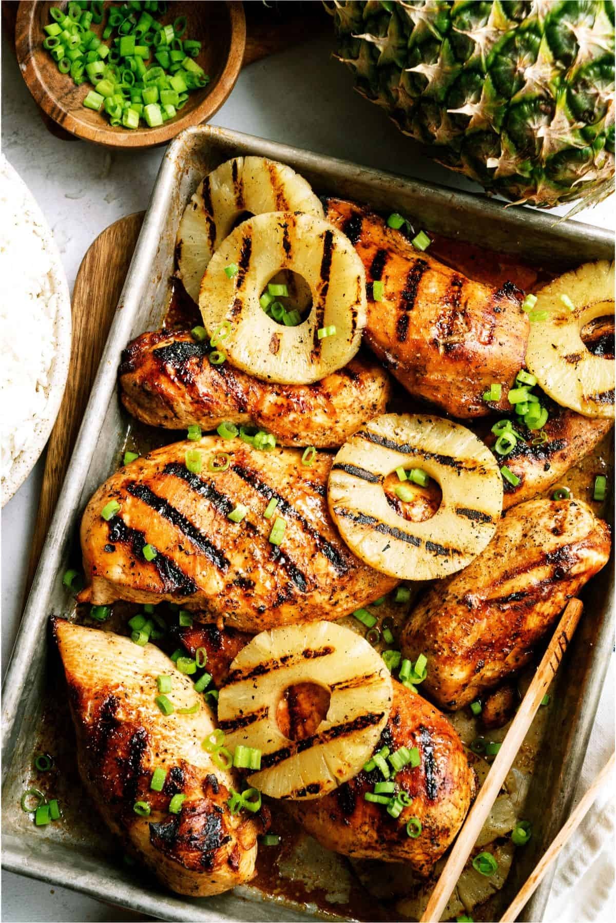 teriyaki pineapple grilled chicken on a grill with pineapple slices