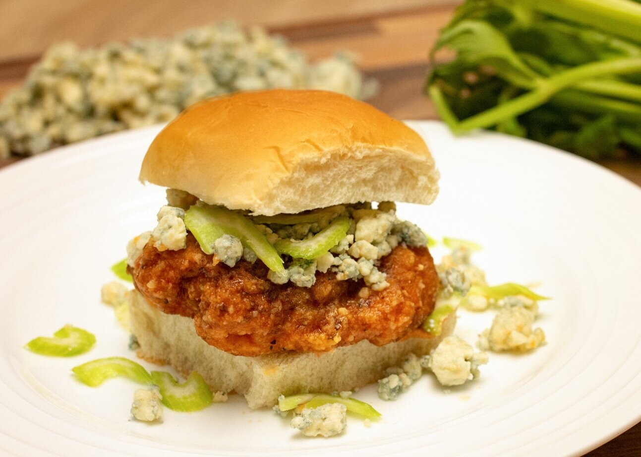 plate of buffalo chicken sliders with blue cheese dressing and celery sticks