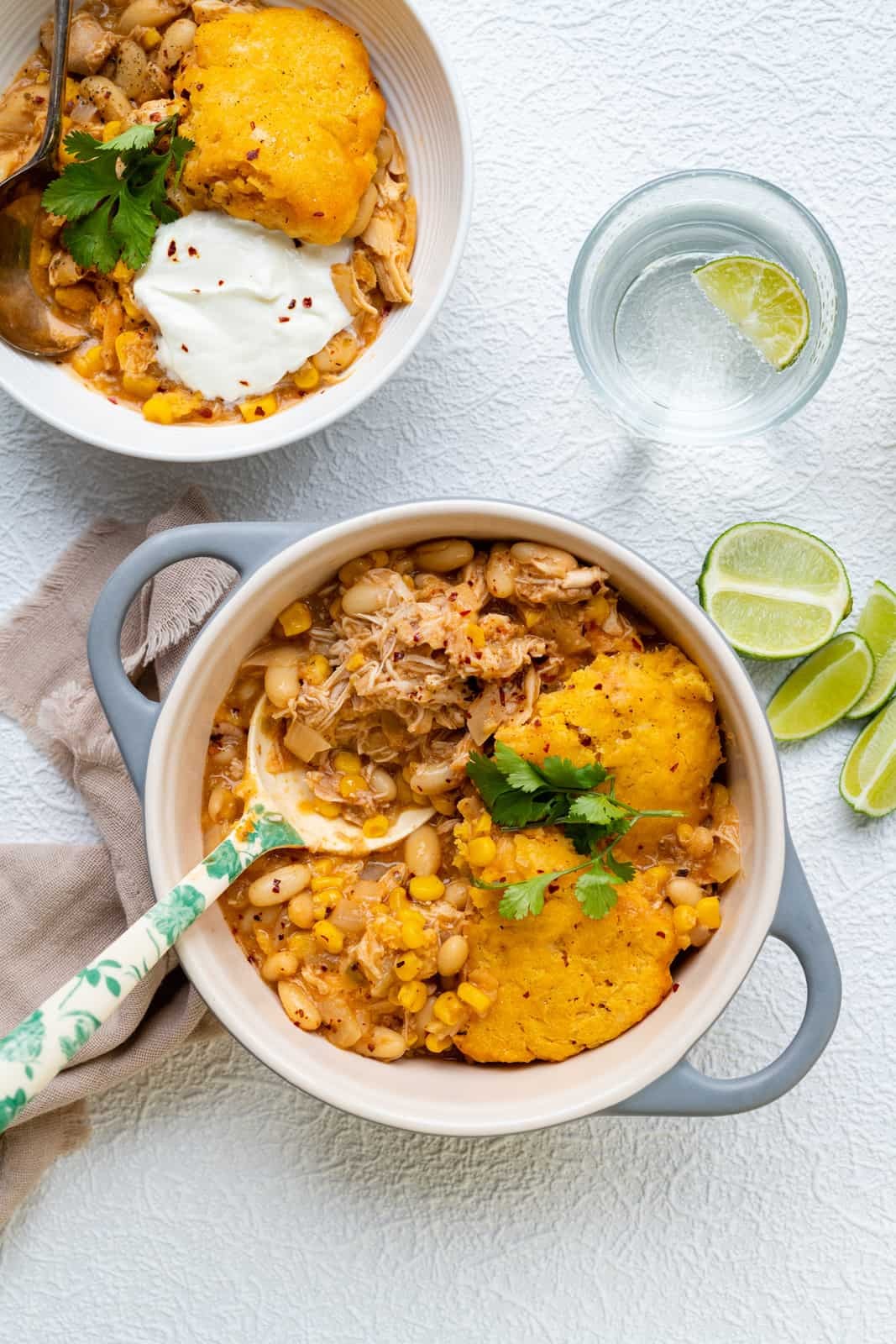 hearty white chicken chili in a ceramic bowl with cornbread, cozy setting, comfort food