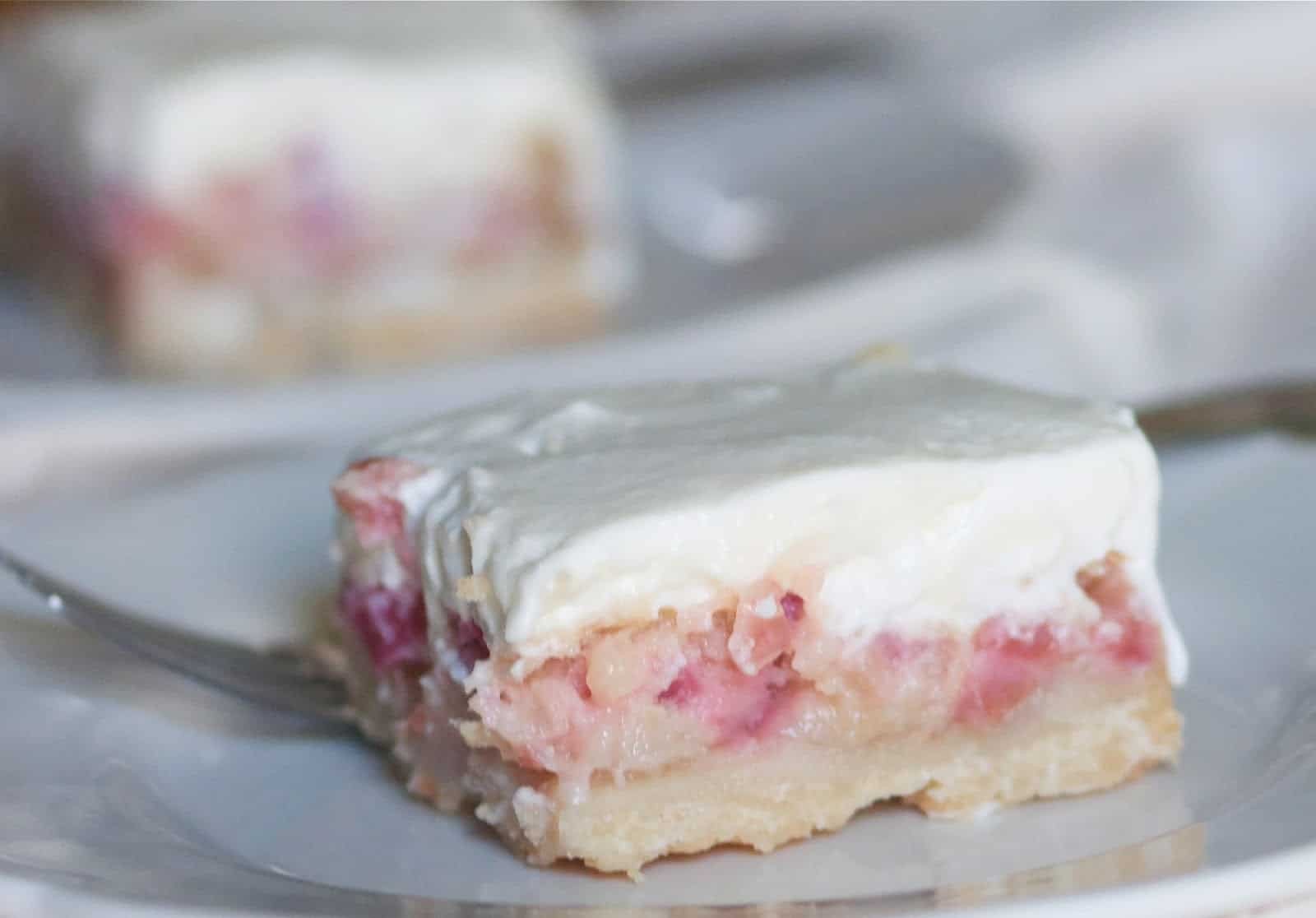 close-up of violet-hued rhubarb dessert with creamy topping