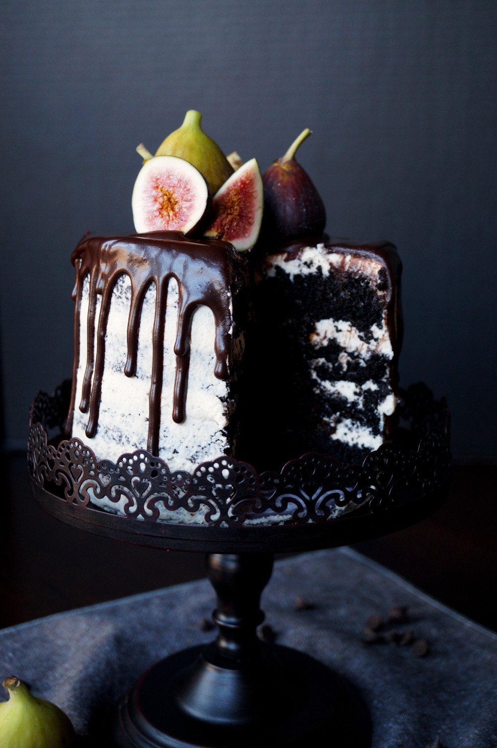 Fig Balsamic Chocolate Layer Cake with a slice cut out on a rustic wooden table.