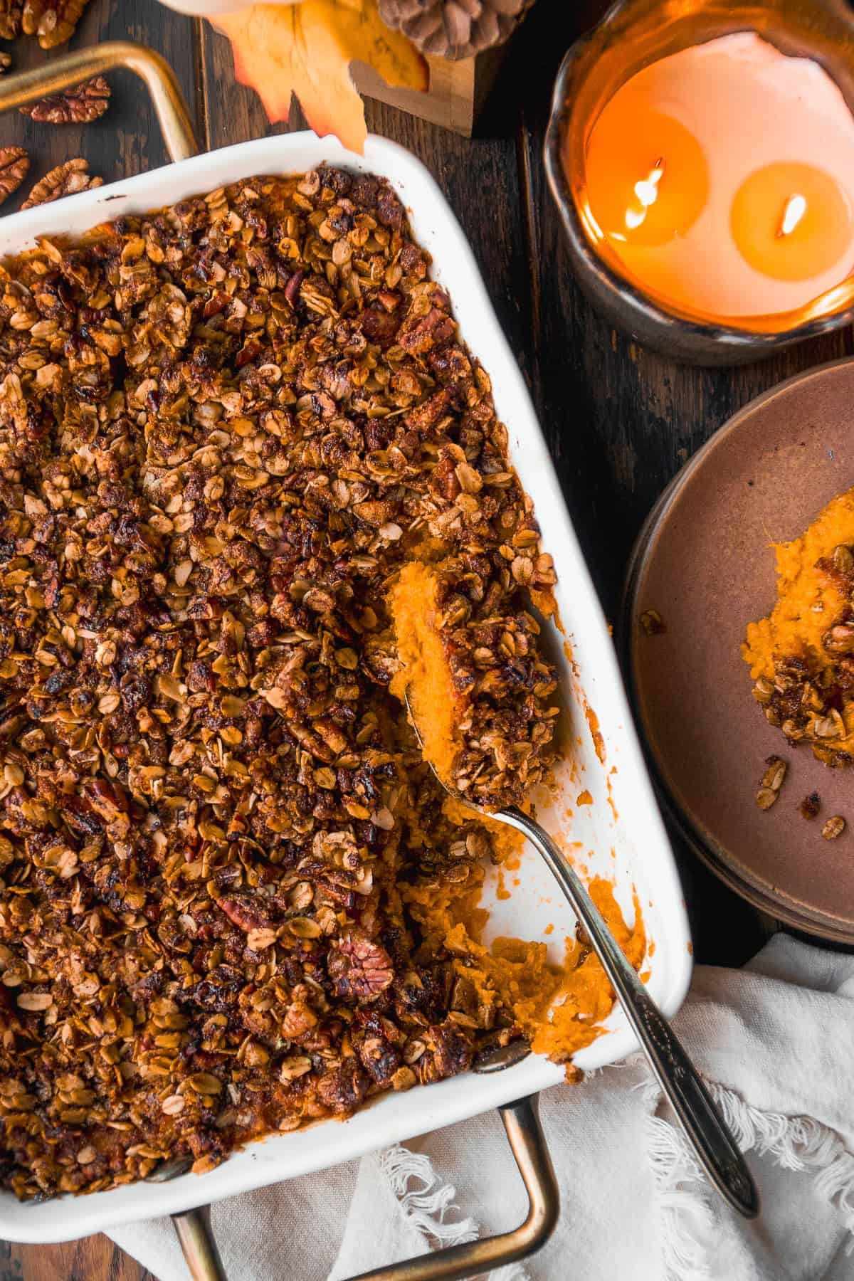 Vibrant maple sweet potato casserole with golden brown pecan and oat crunch topping, steam rising, cozy lighting