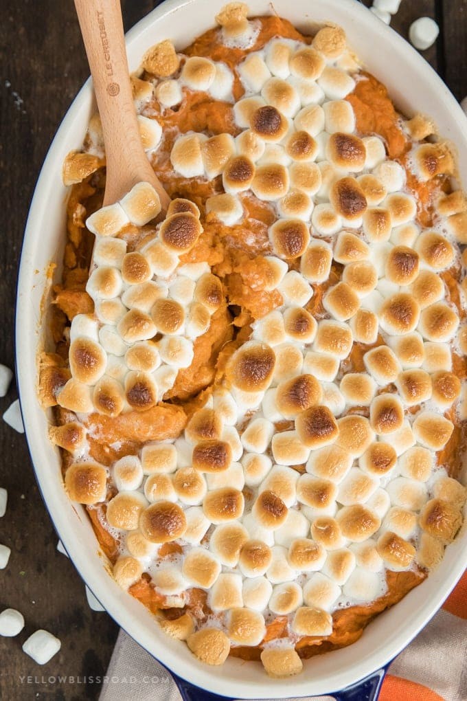close-up creamy sweet potato casserole with toasted marshmallows and golden butter drizzle