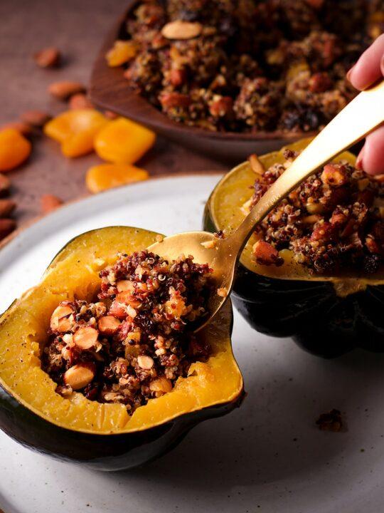 Chicken quinoa stuffed acorn squash on a rustic wooden table